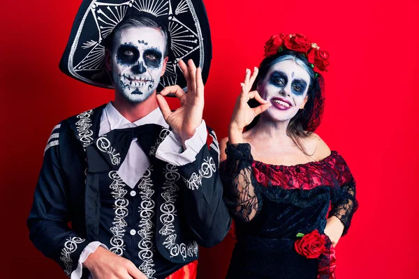 死んだ衣装のメキシコの日を身に着けている若いカップルは 手と指でOkサインを行う肯定的な笑みを浮かべて 成功した表現 — ストック写真
