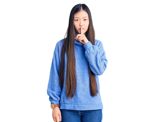 年轻美丽的中国女人穿着宽松的高领毛衣 要求保持安静 手指放在嘴唇上 沉默和秘密概念 — 图库照片