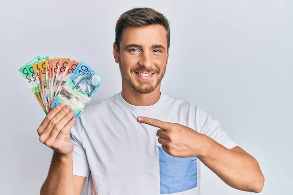 Hombre Caucásico Guapo Sosteniendo Dólares Australianos Sonriendo Feliz Señalando Con —  Fotos de Stock