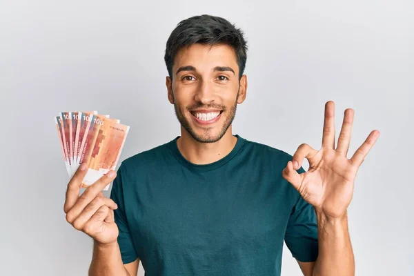 Joven Hombre Guapo Sosteniendo Billetes 100 Noruego Coronas Haciendo Señal — Foto de Stock