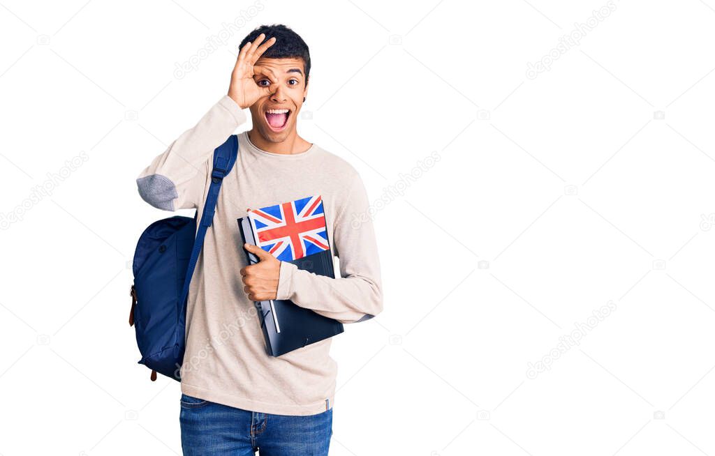 Young african amercian man wearing student backpack holding binder and uk flag smiling happy doing ok sign with hand on eye looking through fingers 
