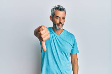 Orta yaşlı, gri saçlı, sıradan kıyafetler giyen mutsuz, kızgın, reddedilmiş ve olumsuz jestler yapan bir adam. kötü ifade. 