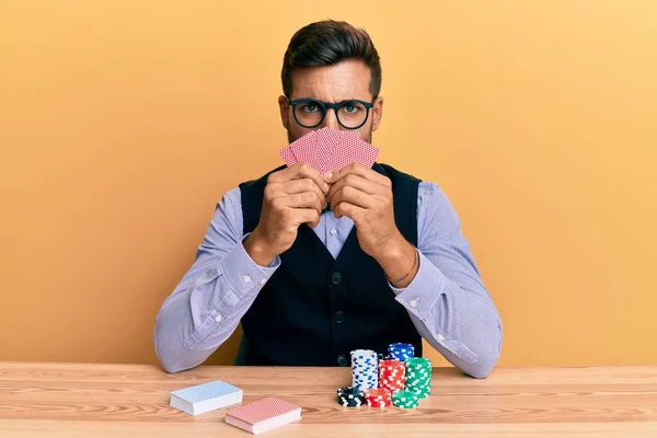 Handsome Hispanic Croupier Man Sitting Table Poker Chips Cards Skeptic — Stock Photo, Image