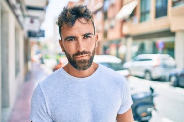 Şehirde yürüyen, ciddi bir ifadeye sahip genç bir İspanyol.