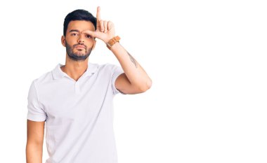 Genç, yakışıklı İspanyol adam günlük kıyafetler giyiyor. Alnında parmakları olan insanlarla alay ediyor. Ezik hareketler yapıyor, alay ediyor.. 