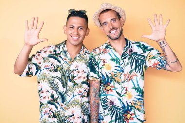 Yazlık şapkalı ve Hawaii gömlekli iki genç eşcinsel on numarayı gösterip gösterirken kendinden emin ve mutlu bir şekilde gülümsüyor.. 