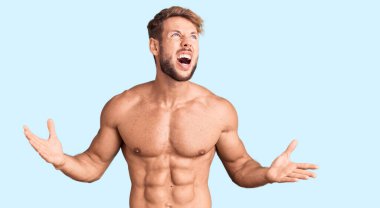 Genç, beyaz bir adam üstsüz, deli deli deli bağırıyor, agresif bir ifadeyle bağırıyor ve kollarını kaldırıyor. hüsran kavramı. 