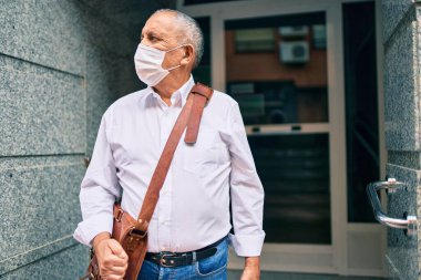 Kıdemli işadamı gülümseyerek şehirde mutlu mesut yürüyor..