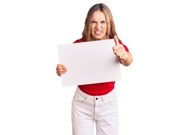 Boş pankart tutan genç, güzel sarışın kadın öfkeyle bağırıyor, öfkeyle bağırıyor ve el kaldırıyor. 