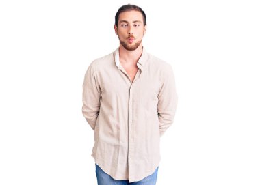 Genç, beyaz, sıradan kıyafetler giyen, dudaklarıyla balık suratı yapan, çılgın ve komik bir jest yapan yakışıklı bir adam. Komik ifade. 