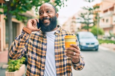 Yakışıklı, modern, sakallı Amerikalı adam şehirde mutlu bir gülümsemeyle konuşuyor.