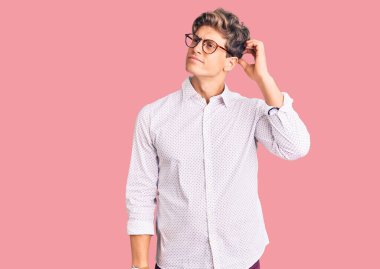 İş kıyafetleri ve gözlük takan genç yakışıklı adam, soru sormayı ve kafa karıştırmayı sever. Şüpheyle kararsız, kafa kafaya düşünerek. Düşünceli kavram. 