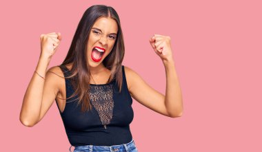 Öfkeli ve kızgın giyinmiş genç İspanyol kadın öfkeyle bağırırken kızgın ve öfkeli yumruklar sallıyor. öfke ve agresif konsept. 