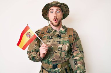 Kamuflaj üniforması giyen genç beyaz adam elinde İspanyol bayrağı tutuyordu. Şaşırmış ve ağzı açık bir şekilde şaşırmıştı. İnanmayan yüz. 
