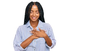 Güzel İspanyol kadın gündelik giysiler giyiyor. Elleri göğsünde, gözleri kapalı gülümsüyor ve yüzünde minnet ifadesi var. sağlık kavramı. 