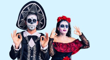 Arka planda Meksika kostümlü genç çift rahatlamış ve parmaklarıyla meditasyon hareketi yaparken gözleri kapalı gülümsüyor. yoga konsepti. 