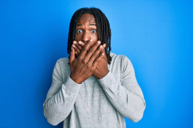 Balıkçı yaka kazak giyen Afro-Amerikalı bir adam ağzı yanlışlıkla ellerle kapatırken şok geçirdi. gizli kavram. 