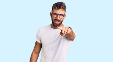 Gündelik kıyafetler giyen ve gözlük takan genç İspanyol adam kameraya kızgın ve sinirli olduğunu gösteriyor. 