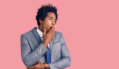 Afro saçlı, iş ceketi giyen yakışıklı Afro-Amerikalı adam ağzıyla ağzını kapatmaktan sıkılmış. Huzursuz ve uykulu.. 