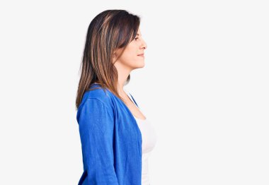 Genç ve güzel bir kadın günlük giysiler giyiyor. Tarafını arıyor, rahat poz veriyor. Kendine güvenen bir gülümsemesi var.. 