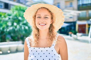 Sarışın, güzel, beyaz bir kadın. Yazın mutlu bir şekilde gülümsüyor.