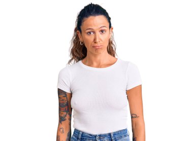 Gündelik beyaz tişörtlü İspanyol bir kadın. Uykulu ve yorgun görünüyor. Yorgunluktan bitkin düşmüş, akşamdan kalma, tembel gözlü.. 