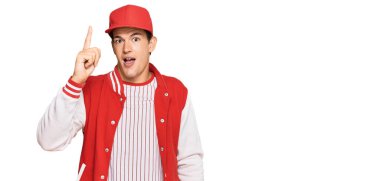 Beyzbol üniforması giyen yakışıklı beyaz adam başarılı bir fikirle işaret ediyor. Heyecanlı ve mutlu. Bir numara.. 