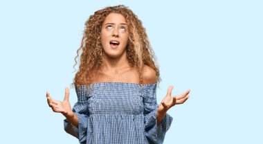 Yazlık elbiseler giyen beyaz güzel bir kız. Deli gibi bağırıyor, agresif bir ifadeyle bağırıyor ve kollarını kaldırıyor. hüsran kavramı. 