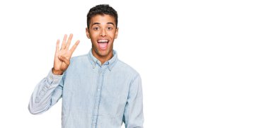 Genç, yakışıklı, Afro-Amerikalı, günlük kıyafetler giymiş dört numaralı parmaklarıyla kendini beğenmiş ve mutlu bir şekilde onu işaret ediyor.. 