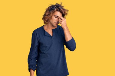 Günlük kıyafetler giyen genç İspanyol adam yorgun burnu ve gözleri ovuşturup yorgun ve baş ağrısı çekiyor. Stres ve hüsran kavramı. 