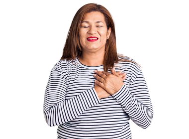 Kısa saçlı, beyaz arka planda günlük kıyafetler ve gözlük takan güzel genç bir kadın. Başka tarafa bakıyor.