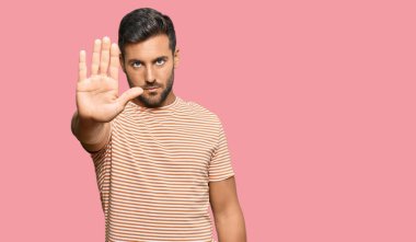 Günlük kıyafetler giyen yakışıklı İspanyol adam avucunun içi gibi şarkı söylemeyi kesiyor. Yüzünde olumsuz ve ciddi bir jest olan uyarı ifadesi. 