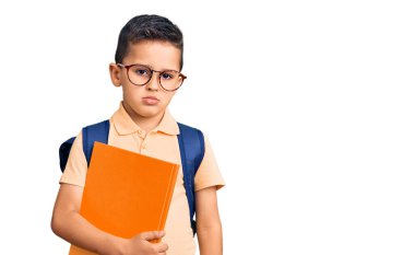 Okul çantası takan, kitap tutan, düşünceli, ayık bakışlı, kendine güvenen bir çocuk. 