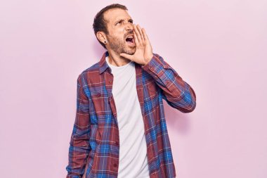 Sıradan kıyafetler giyen genç yakışıklı adam el ele verip bağırarak ve yüksek sesle bağırıyor. iletişim konsepti. 