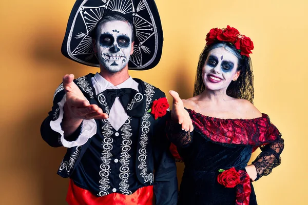 死んだ衣装のメキシコの日を身に着けている若いカップルは 挨拶や歓迎として握手を提供する黄色の笑顔に優しい 成功したビジネス — ストック写真