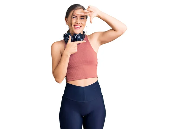 Hermosa Mujer Joven Caucásica Usando Ropa Gimnasio Usando Auriculares Sonriendo —  Fotos de Stock