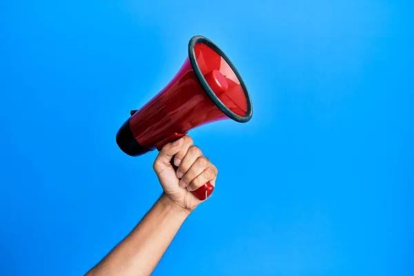 Mão Homem Hispânico Segurando Megafone Sobre Fundo Azul Isolado — Fotografia de Stock