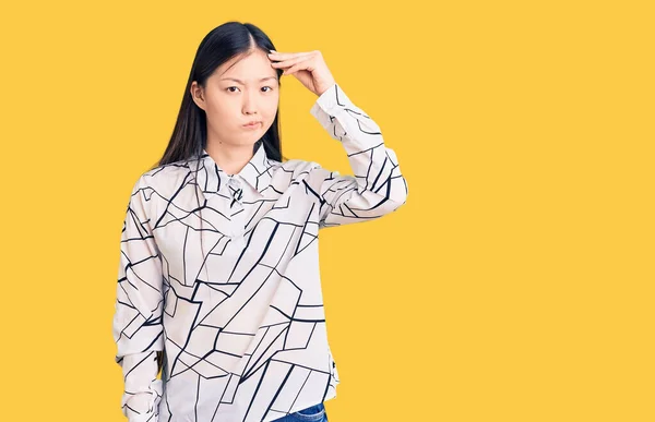 若い美しい中国の女性は カジュアルシャツを着て心配し 額に手で問題について強調しました 危機への神経と不安 — ストック写真