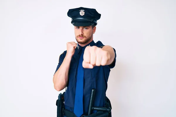 警察の制服を着た若い白人男性が戦うために拳を打ちます 積極的かつ怒りの攻撃 脅威と暴力 — ストック写真