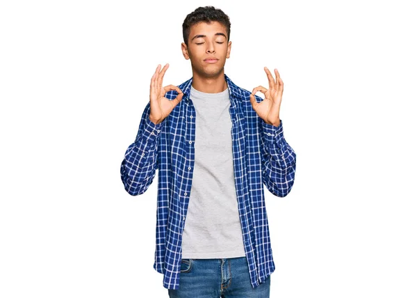 カジュアルな服を着た若いハンサムなアフリカ系アメリカ人男性は 指で瞑想ジェスチャーを行う閉じて目でリラックスして笑顔 ヨガのコンセプト — ストック写真
