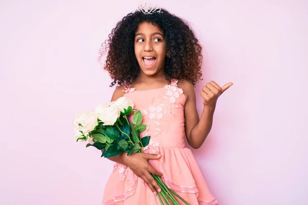 アフリカ系アメリカ人の子供とともに巻き毛を身に着けている王女クラウン保持花親指上側に笑顔幸せなでオープン口 — ストック写真