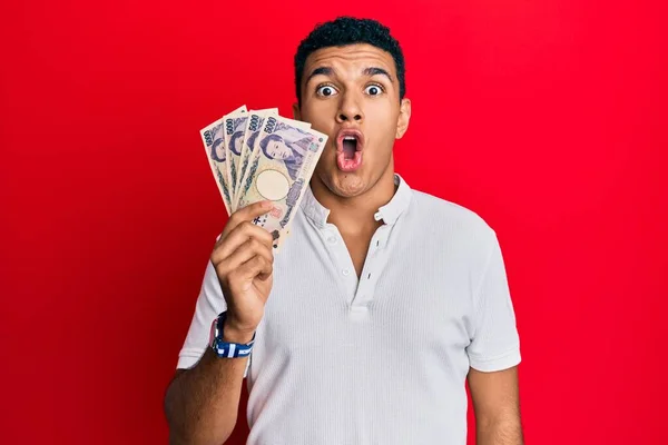 Hombre Árabe Joven Sosteniendo Billetes Yen Japoneses Asustado Sorprendido Con —  Fotos de Stock