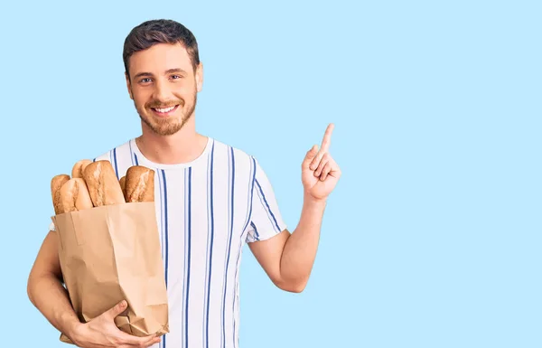 Jovem Bonito Com Urso Segurando Saco Papel Com Pão Surpreso — Fotografia de Stock