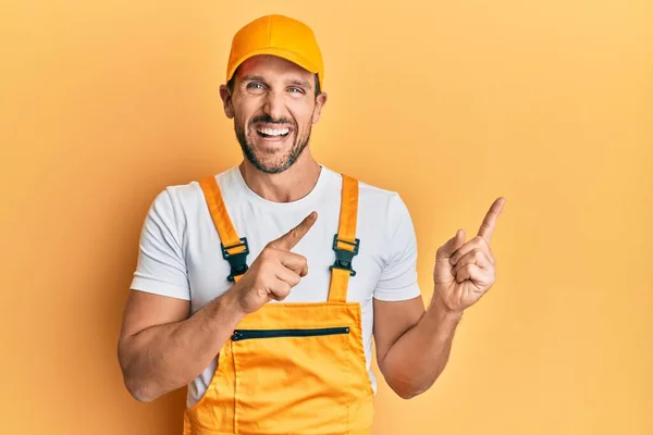 Ung Stilig Man Bär Handyman Uniform Pekar Sidan Leende Och — Stockfoto