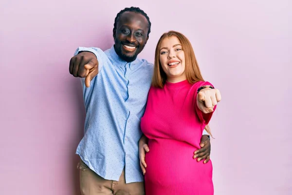 Jovem Casal Interracial Esperando Bebê Tocando Barriga Grávida Apontando Para — Fotografia de Stock