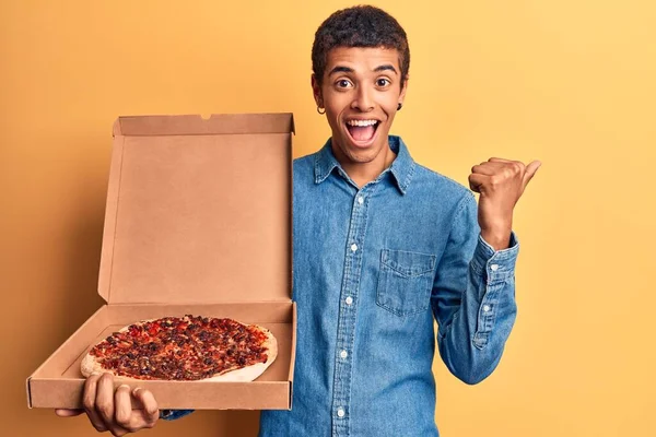 Joven Africano Amerciano Sosteniendo Caja Pizza Entrega Apuntando Pulgar Hacia —  Fotos de Stock
