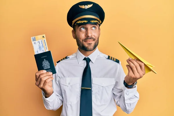 Handsome Hispanic Pilot Man Holding Paper Plane Passport Smiling Looking — Stock Photo, Image