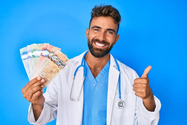 Junger Hispanischer Mann Doktoruniform Hält Kanadische Dollars Der Hand Und — Stockfoto