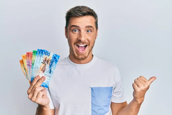 Hombre Caucásico Guapo Sosteniendo Billetes Suizos Franco Apuntando Con Pulgar —  Fotos de Stock