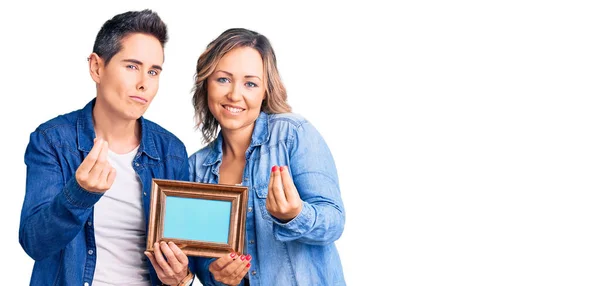 Casal Mulheres Segurando Moldura Vazia Fazendo Gesto Dinheiro Com Mãos — Fotografia de Stock